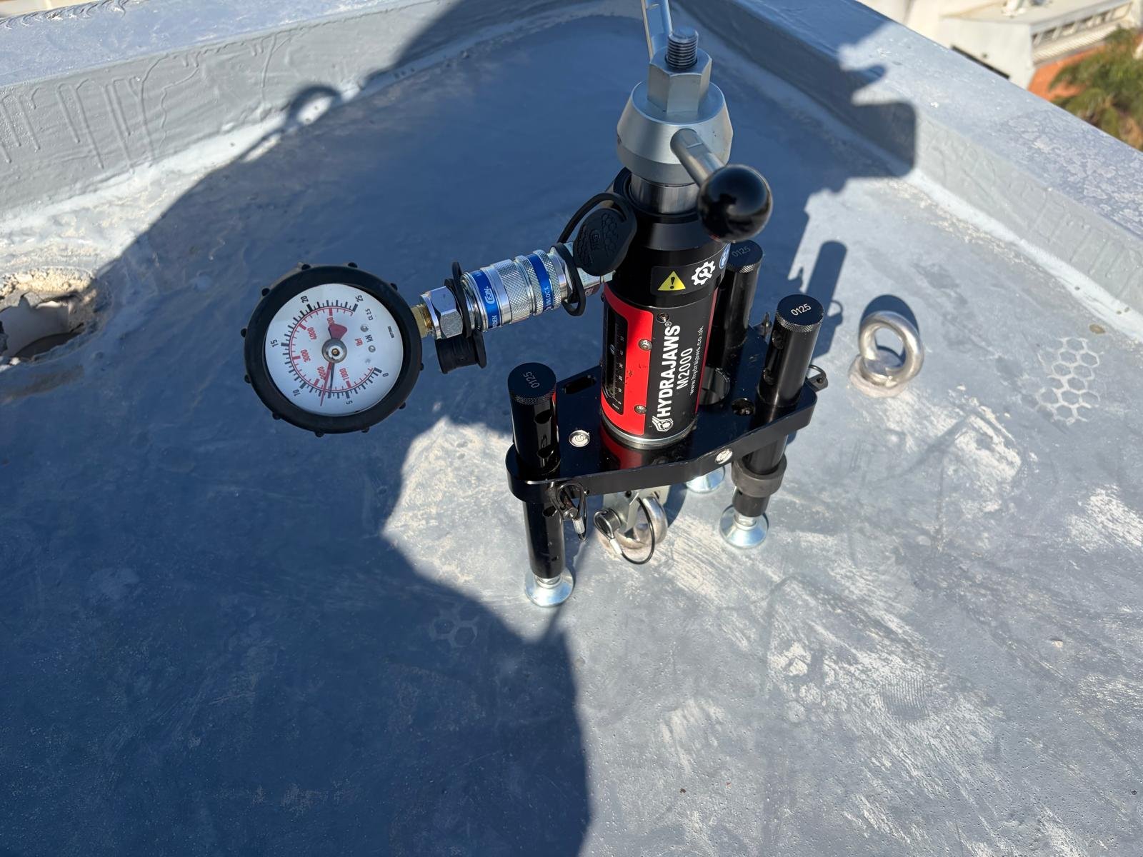 Roof anchor point being load tested with calibrated equipment during recertification in Melbourne