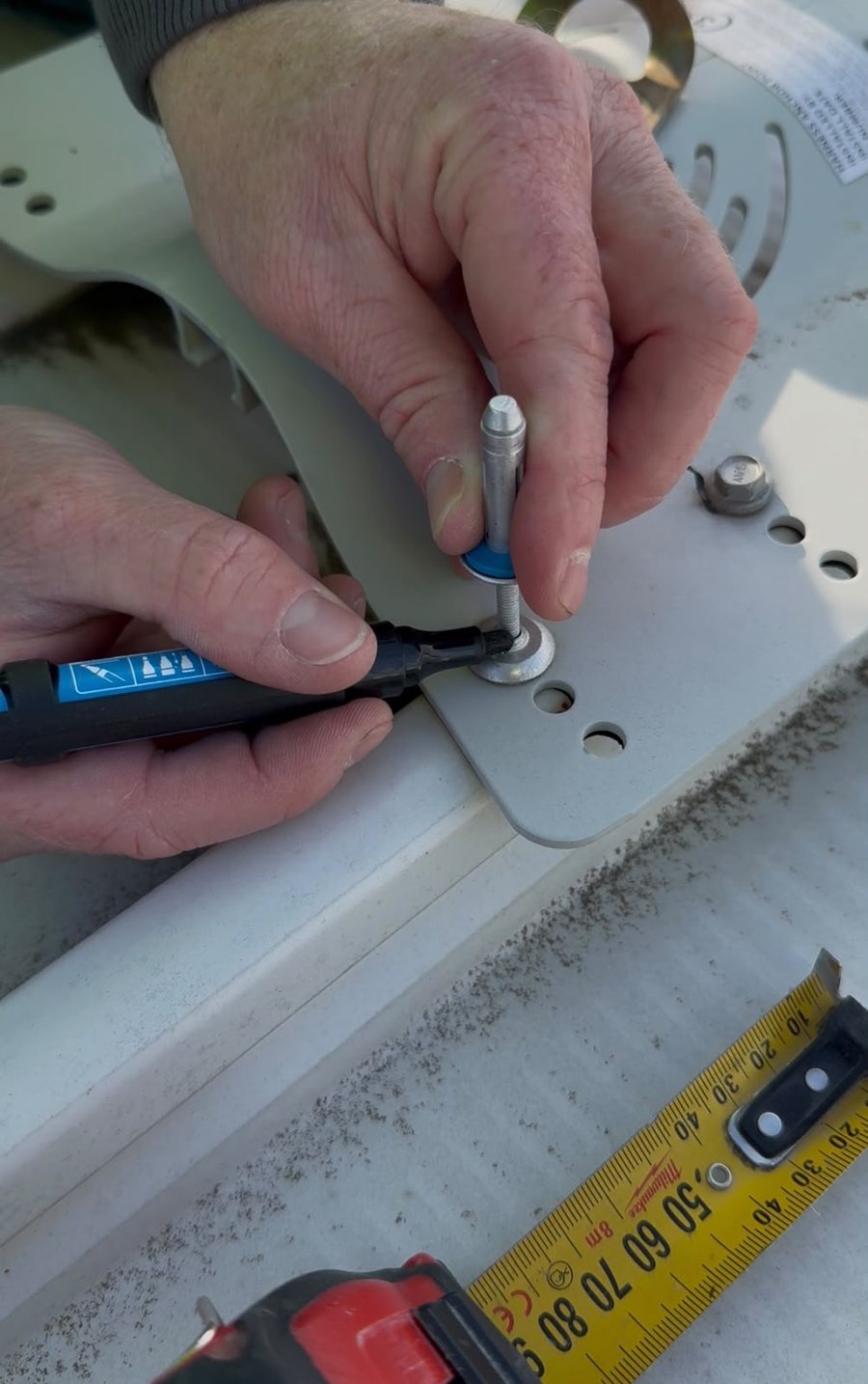 Marking a depth probe at the top of a roof anchor rivet head