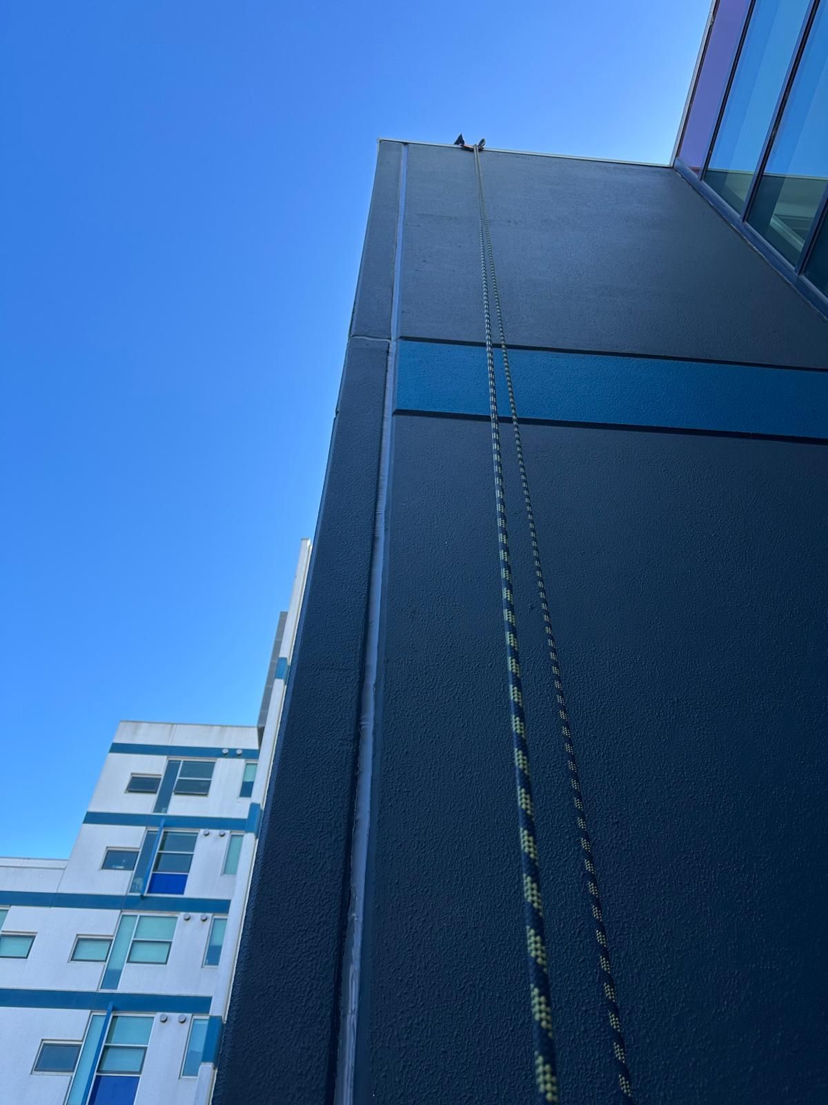Ropes rigged down recaulked building facade Melbourne