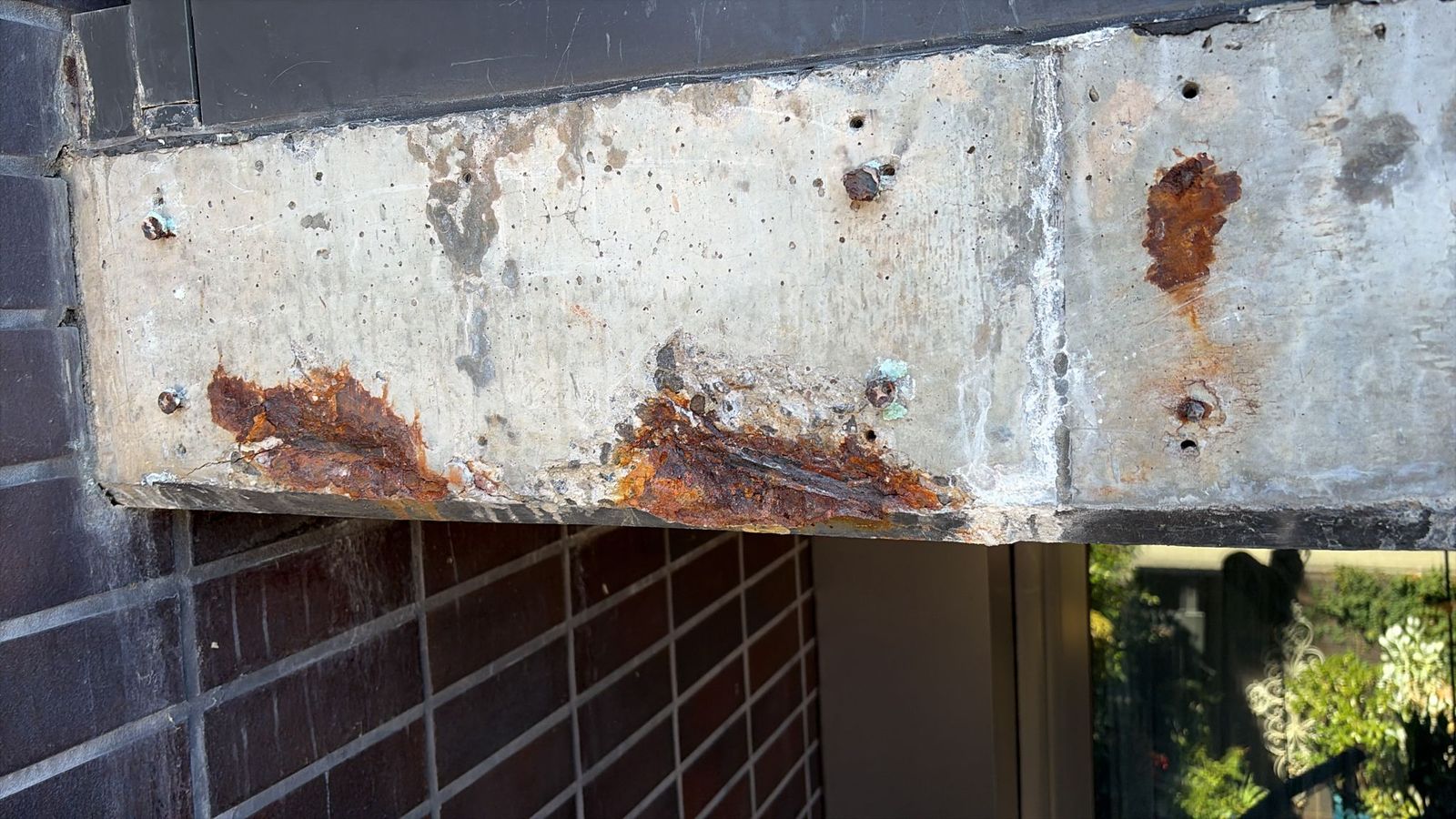 Rust bleeding from embedded steel in concrete balcony edge Melbourne