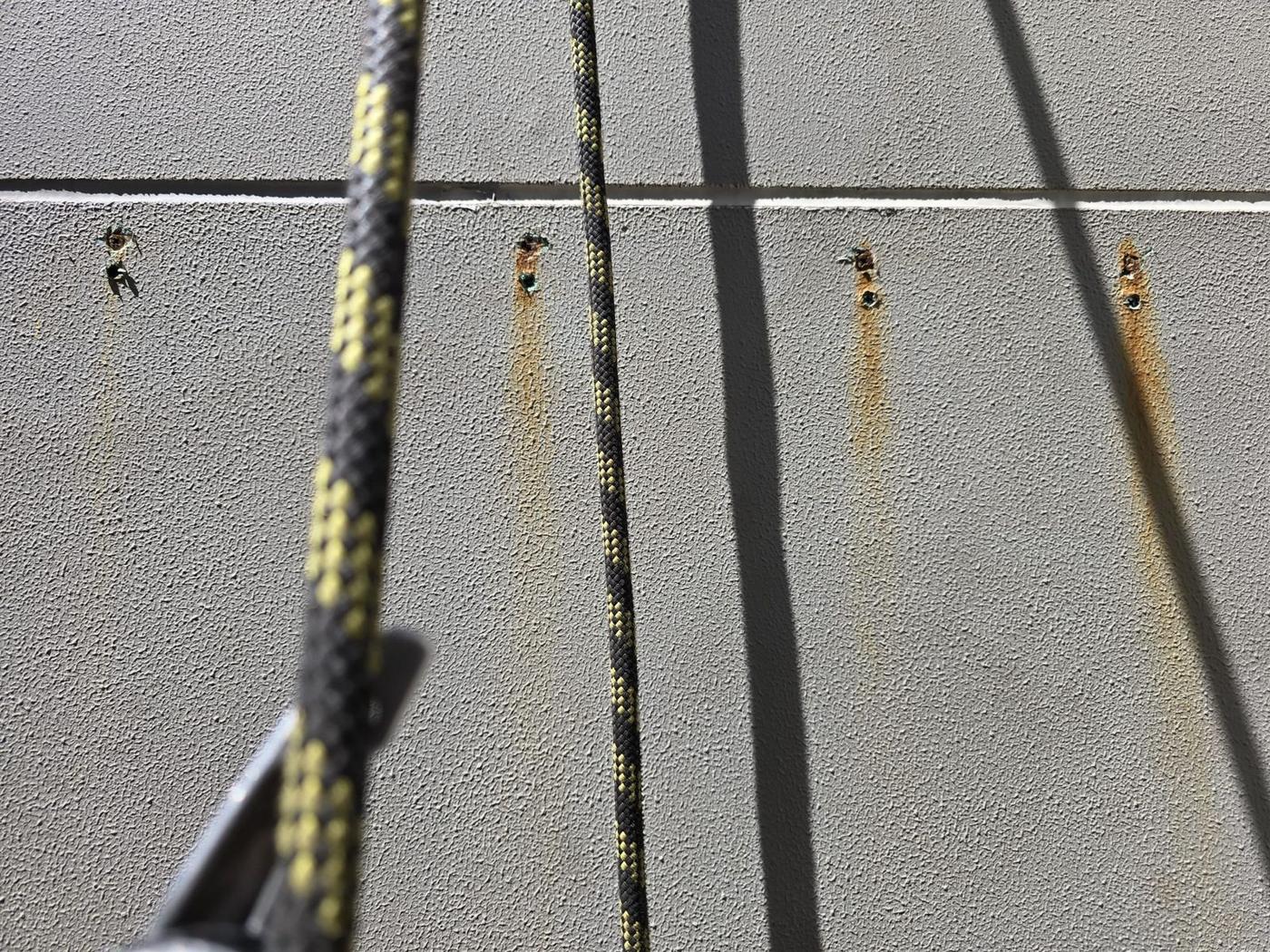 Rust streaks from corroding fixings on facade panels, rope access inspection Melbourne