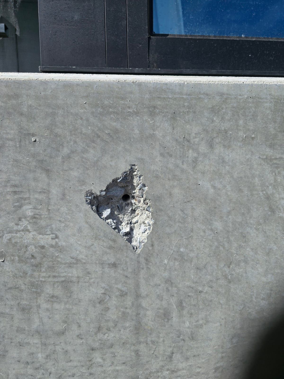 Spalled hole in concrete facade before repair, Carnegie Melbourne