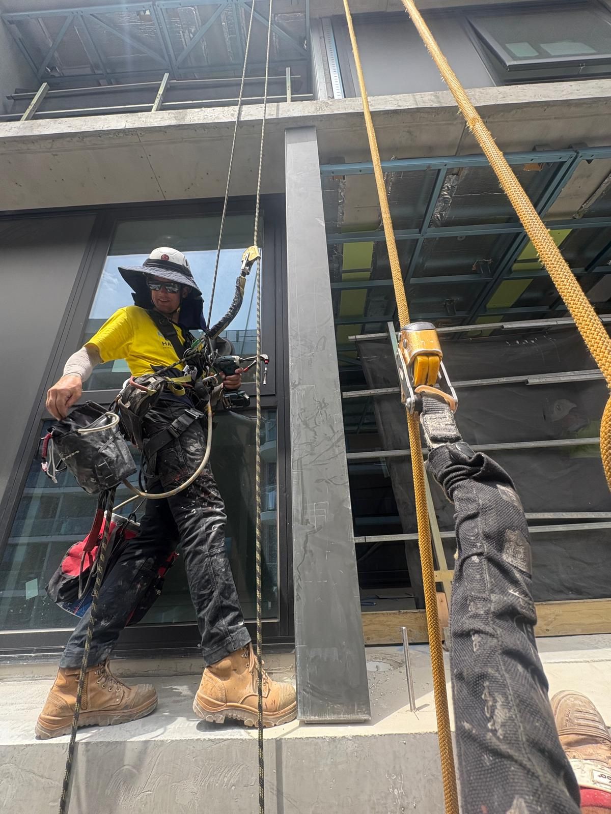 Rope access technician in full kit working on building facade in Melbourne